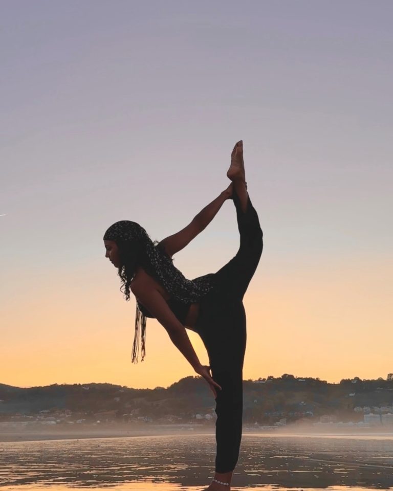 Photo prof de Yoga en peied à la main devant un coucher de soleil